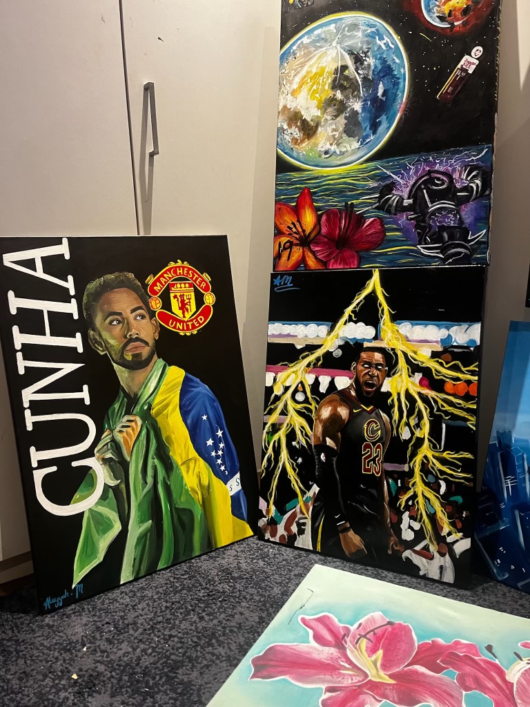 Studio photograph showing several colourful finished canvases together